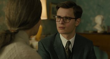 Movie still from “The Goldfinch” (2019), directed by John Crowley – A man in a suit and glasses talking to a woman; Close Up shot, Over the shoulder angle