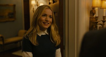 Movie still from “The Goldfinch” (2019), directed by John Crowley – A young blonde woman smiling for the camera; Medium shot, Over the shoulder angle