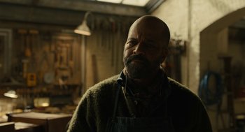 Movie still from “The Goldfinch” (2019), directed by John Crowley – A man with a beard wearing an apron; Close Up shot, Low angle