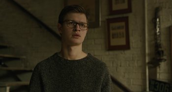 Movie still from “The Goldfinch” (2019), directed by John Crowley – A young man wearing glasses standing in front of a brick wall; Close Up shot, Low angle