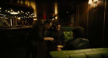 Movie still from “The Goldfinch” (2019), directed by John Crowley – A group of people sitting at a table in a room; Wide shot, High angle