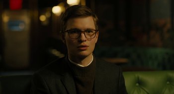 Movie still from “The Goldfinch” (2019), directed by John Crowley – A young man wearing glasses and a suit; Close Up shot, Low angle