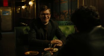 Movie still from “The Goldfinch” (2019), directed by John Crowley – A man sitting in front of another man at a table; Medium shot, Over the shoulder angle
