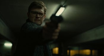 Movie still from “The Goldfinch” (2019), directed by John Crowley – A man holding a gun in a dark room; Close Up shot, Low angle