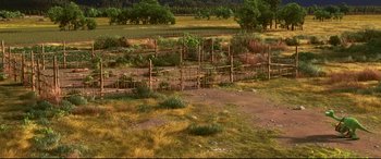 Movie still from “The Good Dinosaur” (2015), directed by Peter Sohn – An open field with a wooden fence and a few trees in the background; Extreme Wide shot, High angle