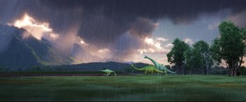 Movie still from “The Good Dinosaur” (2015), directed by Peter Sohn – A group of dinosaurs in the grass under a cloudy sky; Extreme Wide shot, Low angle