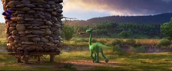 Movie still from “The Good Dinosaur” (2015), directed by Peter Sohn – A green dinosaur with a stick in its mouth; Wide shot, Over the shoulder angle