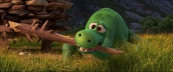 Movie still from “The Good Dinosaur” (2015), directed by Peter Sohn – A green dinosaur is holding a stick in its mouth; Wide shot, High angle