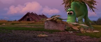Movie still from “The Good Dinosaur” (2015), directed by Peter Sohn – A green creature sitting on top of a rock; Extreme Wide shot, High angle