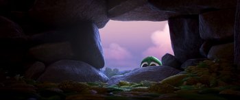 Movie still from “The Good Dinosaur” (2015), directed by Peter Sohn – A cartoon character's face in a cave; Wide shot, High angle
