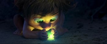 Movie still from “The Good Dinosaur” (2015), directed by Peter Sohn – A child laying on the ground holding a flashlight; Extreme Close Up shot, Overhead angle