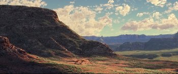 Movie still from “The Good Dinosaur” (2015), directed by Peter Sohn – A mountain with a grassy area in front of it; Extreme Wide shot, High angle