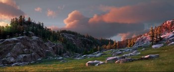 Movie still from “The Good Dinosaur” (2015), directed by Peter Sohn – A view of a grassy area with rocks in the foreground; Extreme Wide shot, Low angle