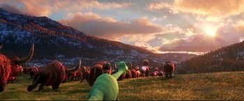 Movie still from “The Good Dinosaur” (2015), directed by Peter Sohn – A group of animals that are standing in the grass; Extreme Wide shot, High angle