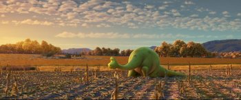 Movie still from “The Good Dinosaur” (2015), directed by Peter Sohn – A green dinosaur is sitting in a field; Wide shot, High angle