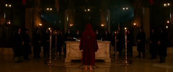 Movie still from “The Good Shepherd” (2006), directed by Robert De Niro – A man in a red robe standing in front of a group of people; Wide shot, High angle