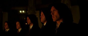 Movie still from “The Good Shepherd” (2006), directed by Robert De Niro – A group of men standing next to each other in a dark room; Medium shot, Low angle