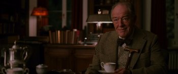 Movie still from “The Good Shepherd” (2006), directed by Robert De Niro – An older man sitting at a table with a cup of coffee; Close Up shot, Over the shoulder angle