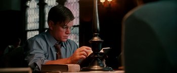 Movie still from “The Good Shepherd” (2006), directed by Robert De Niro – A man sitting at a table looking at his cell phone; Medium shot, Low angle