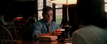 Movie still from “The Good Shepherd” (2006), directed by Robert De Niro – A man sitting in front of a lamp on a table; Medium shot, Low angle
