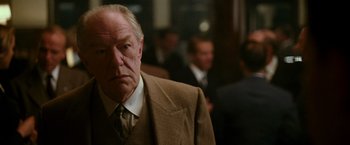 Movie still from “The Good Shepherd” (2006), directed by Robert De Niro – An older man wearing a suit and tie; Close Up shot, Low angle