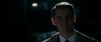 Movie still from “The Good Shepherd” (2006), directed by Robert De Niro – A person wearing a suit and tie; Close Up shot, Over the shoulder angle