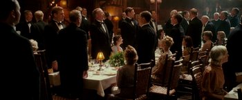 Movie still from “The Good Shepherd” (2006), directed by Robert De Niro – A group of people standing around a dinner table; Wide shot, High angle