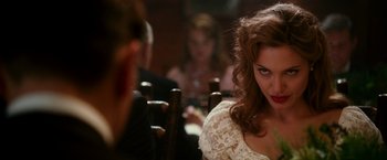 Movie still from “The Good Shepherd” (2006), directed by Robert De Niro – A woman sitting at a table in front of other people; Close Up shot, Over the shoulder angle