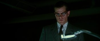 Movie still from “The Good Shepherd” (2006), directed by Robert De Niro – A man in a suit and tie looking at a light; Close Up shot, Low angle