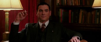Movie still from “The Good Shepherd” (2006), directed by Robert De Niro – A man wearing a suit and tie in a room; Close Up shot, Over the shoulder angle