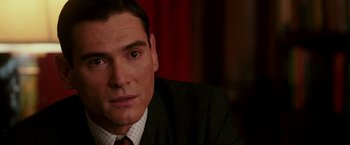 Movie still from “The Good Shepherd” (2006), directed by Robert De Niro – A person wearing a suit and tie; Close Up shot, Over the shoulder angle