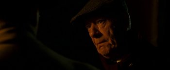 Movie still from “The Good Shepherd” (2006), directed by Robert De Niro – An older man wearing a hat with a cigarette in his mouth; Close Up shot, Over the shoulder angle