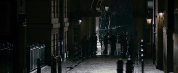 Movie still from “The Good Shepherd” (2006), directed by Robert De Niro – A group of people standing on a sidewalk at night; Extreme Wide shot, High angle