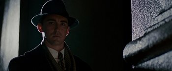 Movie still from “The Good Shepherd” (2006), directed by Robert De Niro – A man wearing a hat and a tie; Close Up shot, Low angle