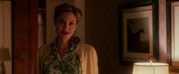 Movie still from “The Good Shepherd” (2006), directed by Robert De Niro – A woman in a green floral shirt and a white jacket; Medium shot, Over the shoulder angle