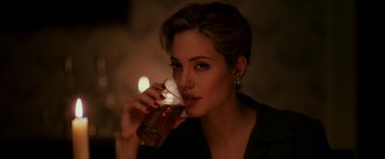 Movie still from “The Good Shepherd” (2006), directed by Robert De Niro – A beautiful woman drinking a glass of beer; Close Up shot, Over the shoulder angle