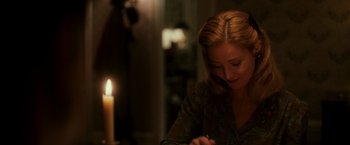 Movie still from “The Good Shepherd” (2006), directed by Robert De Niro – A woman sitting in front of a lit candle; Close Up shot, Over the shoulder angle