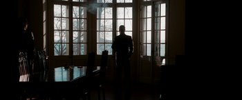 Movie still from “The Good Shepherd” (2006), directed by Robert De Niro – A man standing in front of a window in a room; Wide shot, Low angle