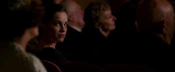 Movie still from “The Good Shepherd” (2006), directed by Robert De Niro – A woman sitting in front of an audience in a theater; Close Up shot, Over the shoulder angle