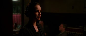 Movie still from “The Good Shepherd” (2006), directed by Robert De Niro – A woman in a black jacket and a white necklace; Close Up shot, Low angle