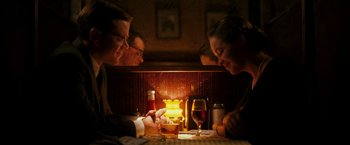 Movie still from “The Good Shepherd” (2006), directed by Robert De Niro – A group of people sitting at a table with a lit candle; Medium shot, Over the shoulder angle