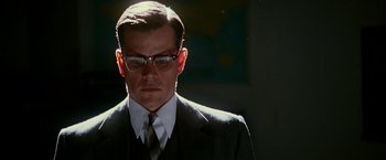 Movie still from “The Good Shepherd” (2006), directed by Robert De Niro – A man in a suit and tie with glasses; Close Up shot, Low angle