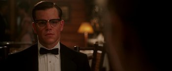 Movie still from “The Good Shepherd” (2006), directed by Robert De Niro – A person wearing a suit and bow tie; Close Up shot, Over the shoulder angle