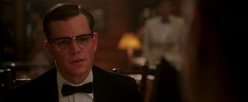 Movie still from “The Good Shepherd” (2006), directed by Robert De Niro – A person wearing a suit and glasses; Close Up shot, Over the shoulder angle
