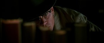 Movie still from “The Good Shepherd” (2006), directed by Robert De Niro – A man wearing glasses and a hat looking at the camera; Close Up shot, Low angle