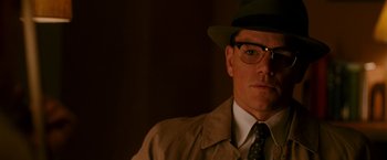 Movie still from “The Good Shepherd” (2006), directed by Robert De Niro – A man in a hat and glasses wearing a hat and glasses; Close Up shot, Low angle