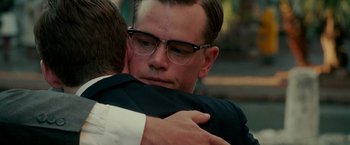 Movie still from “The Good Shepherd” (2006), directed by Robert De Niro – A man hugging another man with his arms wrapped around him; Close Up shot, Over the shoulder angle