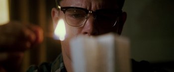 Movie still from “The Good Shepherd” (2006), directed by Robert De Niro – A person wearing glasses looking at a book; Close Up shot, Low angle
