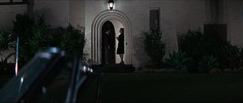 Movie still from “The Graduate” (1967), directed by Mike Nichols – A man and a woman standing in front of a building; Wide shot, Low angle
