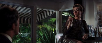 Movie still from “The Graduate” (1967), directed by Mike Nichols – A woman sitting on a chair holding a cigarette in her hand; Medium shot, Low angle